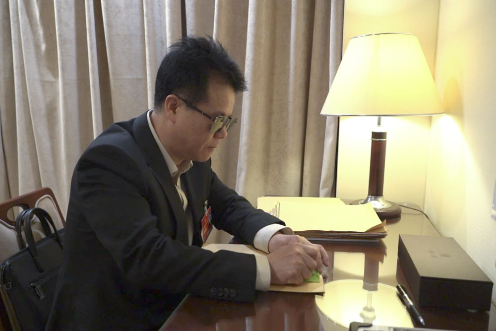 2023年3月7日，王永澄在驻地房间用盲文纸书写建议。新华社记者 张辛欣 摄